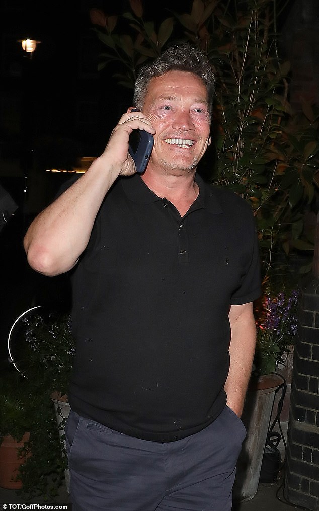 The former EastEnders actor, 52, beamed as he chatted on his phone as he made his way out into the street.