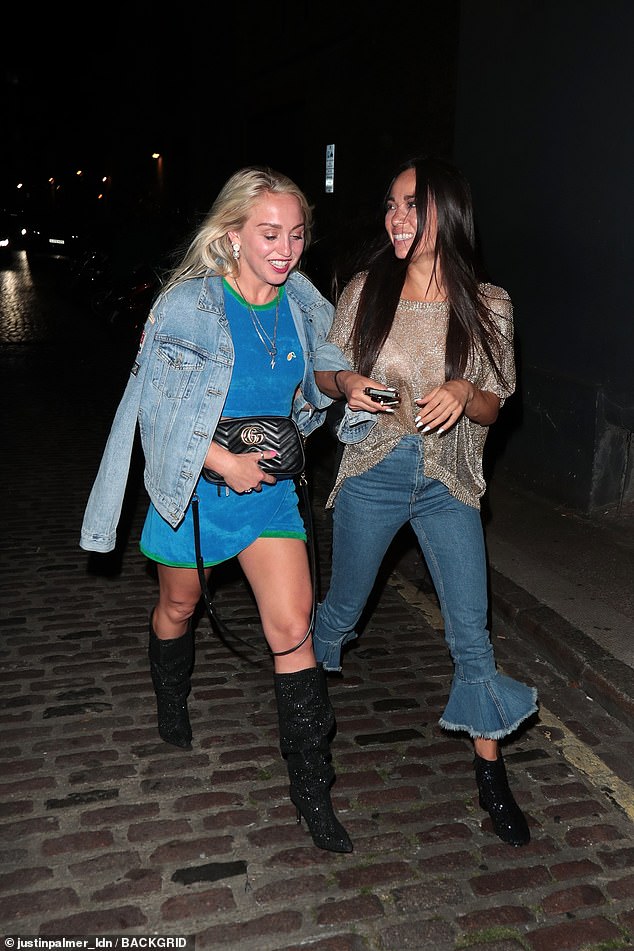 Aimee and Katya held arms as they strolled together outdoors.