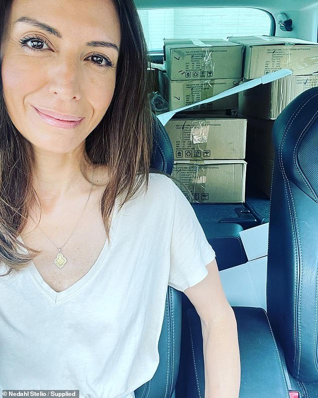 The mother of two is pictured with a car full of boxes containing her products.