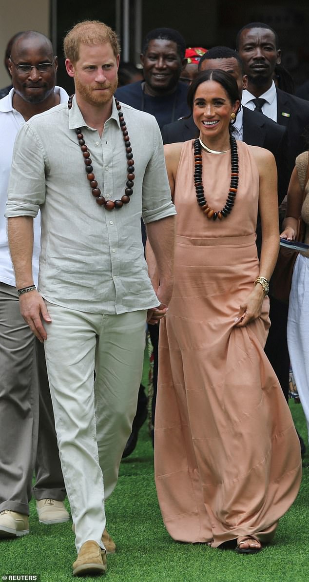 Prince Harry and Meghan walk out after meeting students at the Lightway Academy in Abuja, Nigeria, on May 10.