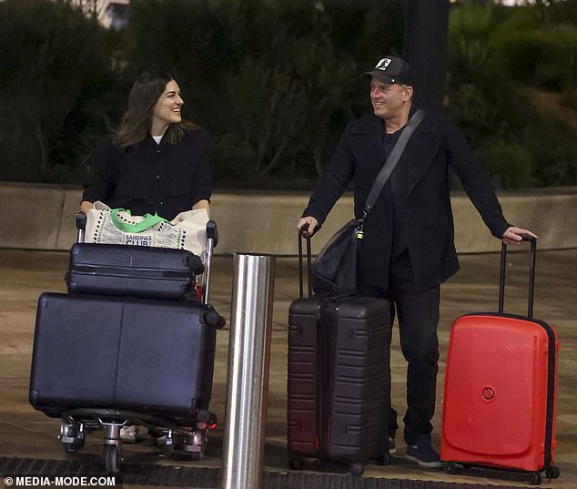 The pair looked in high spirits as they headed to the airport, appearing to share a joke, with Karl and Sarah smiling broadly as they pushed their luggage.