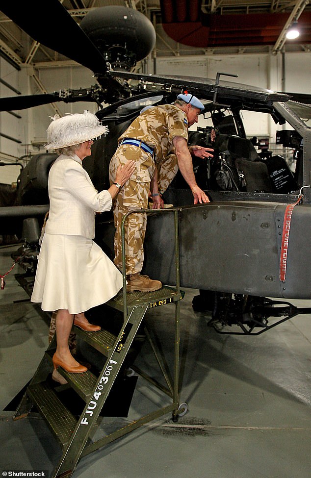 Camilla offers a hand to Charles as he climbs the stairs to see an Apache helicopter during a visit to Wattisham airfield in Ipswich in 2009. There, Charles presented service medals to members of the 4th Army Air Corps Regiment.