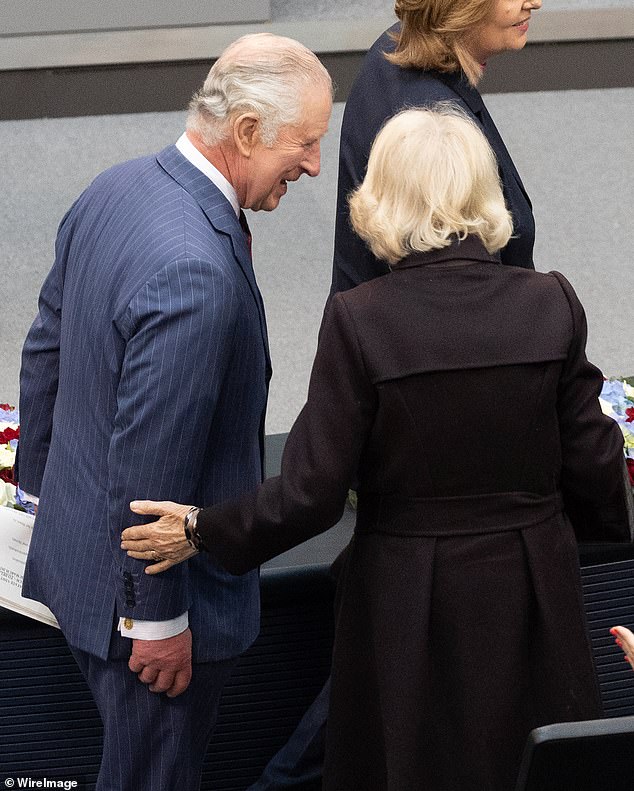 Camilla places a loving hand on Charles' arm at the Bundestag in Berlin during their state visit to Germany, March 2023. They travelled to Berlin, Brandenburg and Hamburg over the three days.