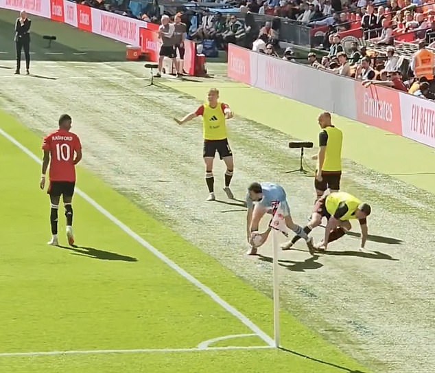 As he collects the ball, he can be seen turning his back on Evans (right), who takes off.