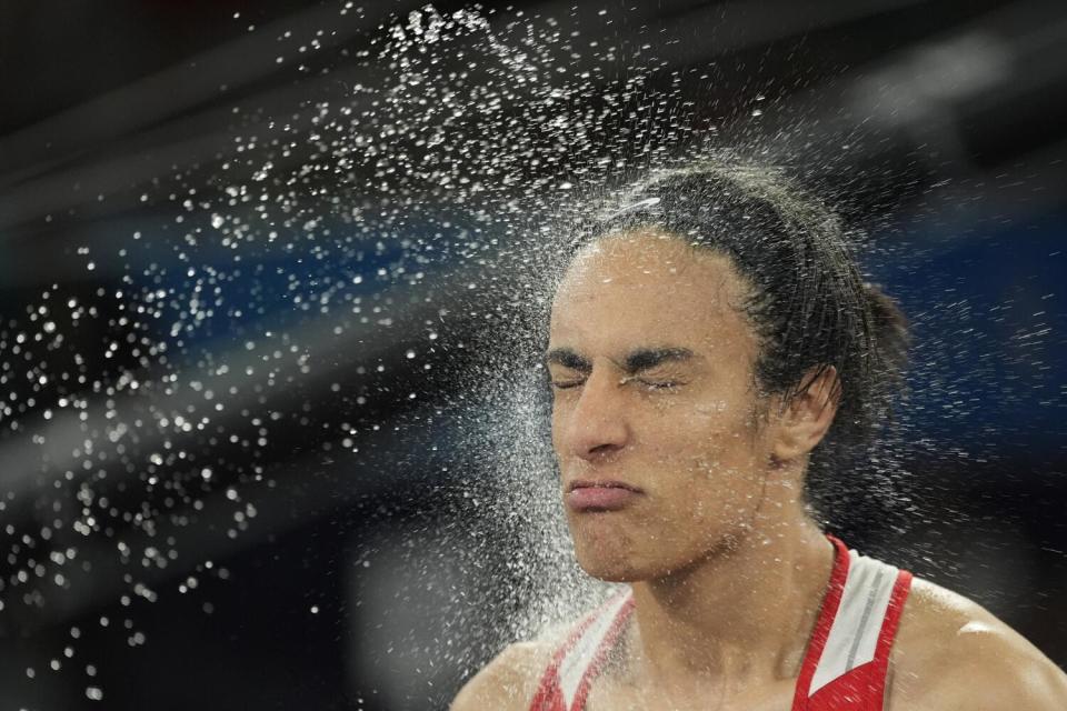 Algerian boxer Imane Khelif is sprayed with water before her fight against China's Yang Liu during the Olympics.