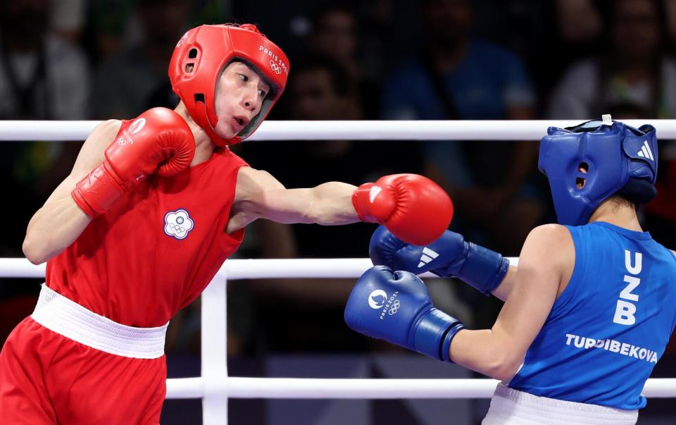 Uzbek Sitora Turdibekova, blue, avoids a punch from Taipei's Yu Ting Lin in Paris.