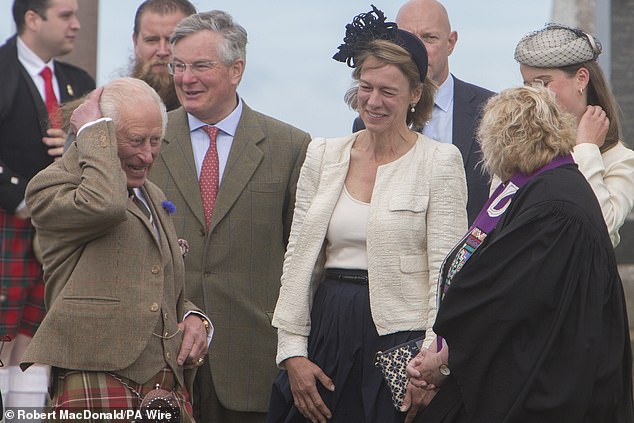 King Charles was pictured battling a gust of wind as he left a church service in Caithness, Scotland.