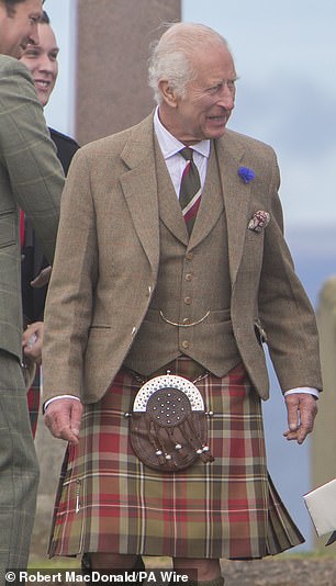 The King wore a red and brown checked jacket and waistcoat.