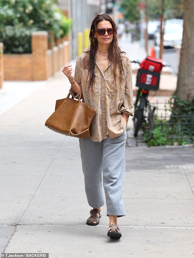 Her hair looked as if it had been washed and air dried and she accessorized with layered necklaces and sunglasses and a large brown leather handbag.