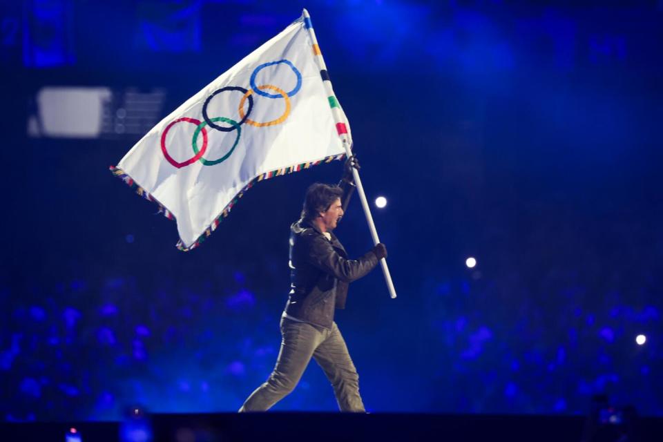 Tom Cruise carries the Olympic flag during the closing ceremony of the Paris 2024 Olympic Games at the Stade de France on Sunday.