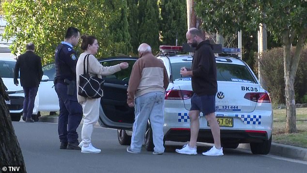 The man was escorted by officers to the back of a police car waiting outside the home.