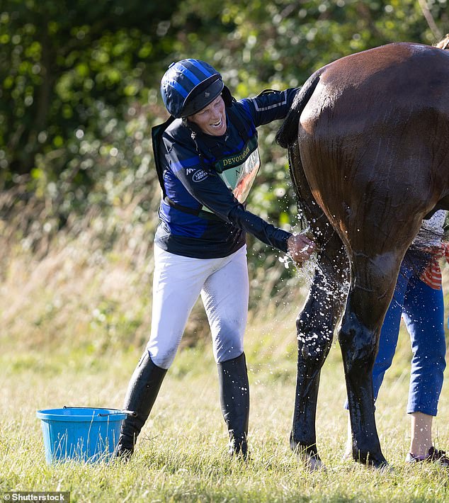 The royal, pictured, looked in high spirits as she wrapped up the day by washing her horse in the sunshine.