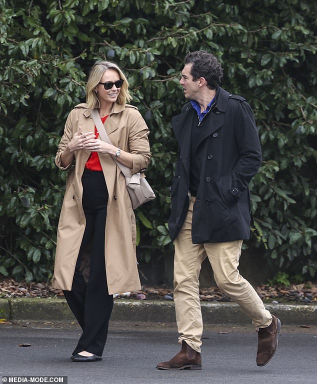 Sylvia looked stylish in a bright red blouse under a long camel-coloured trench coat.