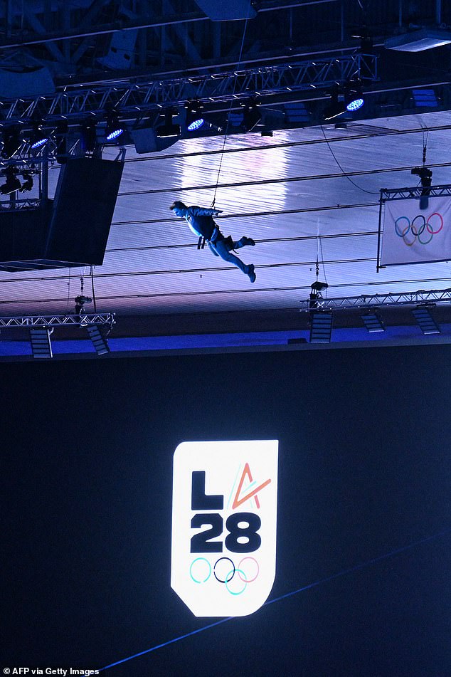 Actor Tom Cruise descends from the stadium roof as part of the Los Angeles 2028 (LA28) award ceremony