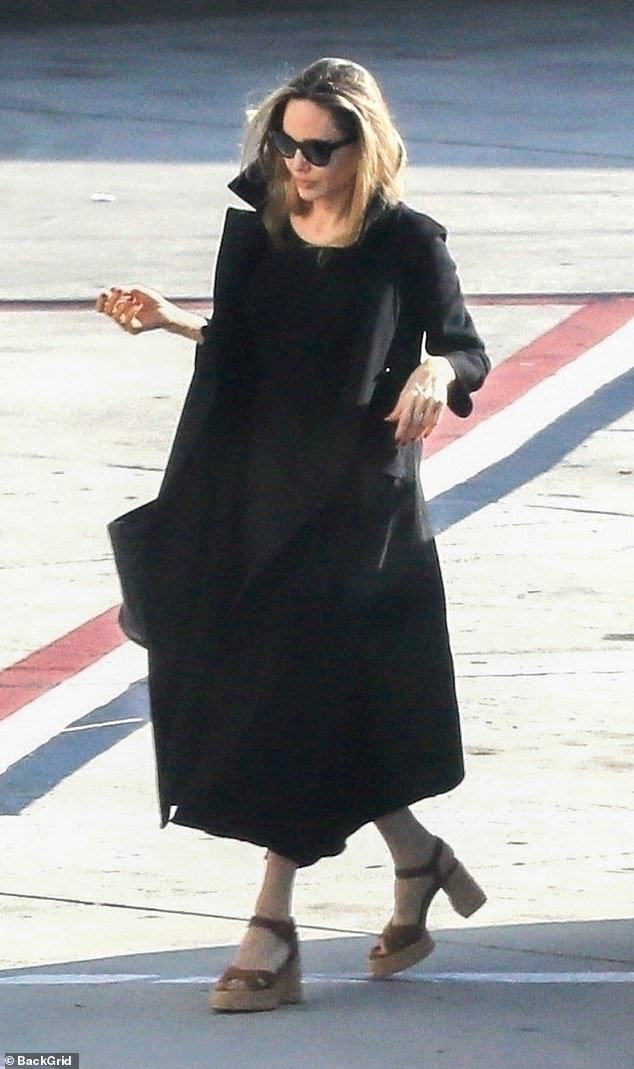 The 49-year-old mother of six, who shares her brood with ex-husband Brad Pitt, wore an all-black outfit consisting of a long dress and coat.