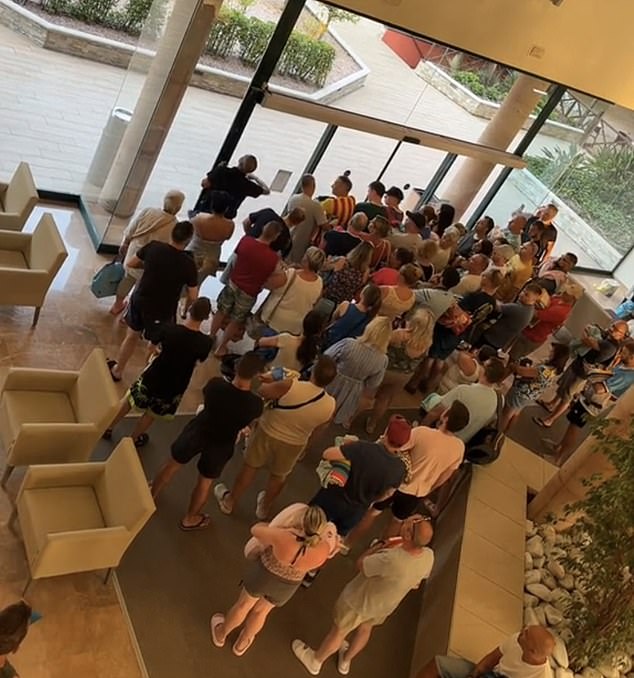 Armed with towels in hand, newly released images show holidaymakers crowded at the entrance to the pool, ready for the morning rush to get the first sun loungers.