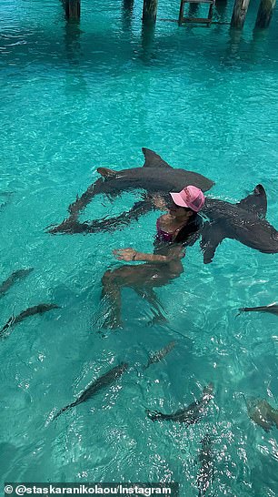 She was seen taking a dip in shallow water with baby sharks circling her.