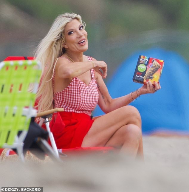 Enjoying the ocean breeze, the Los Angeles native modeled a low-cut plaid top and chic red shorts that flaunted her slender figure.