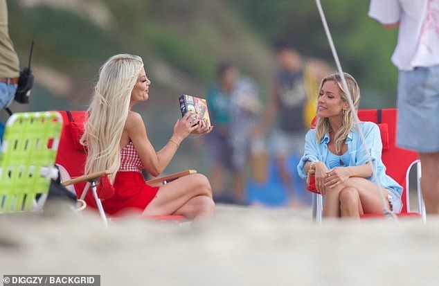 Spelling let her long golden locks down, cascading over her shoulders as she accessorized the look with sleek red heels and showed off the granola bars.