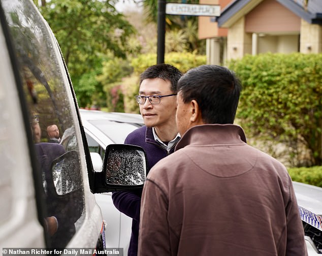 Professor Wang's colleagues are pictured speaking to detectives at the crime scene on Wednesday.