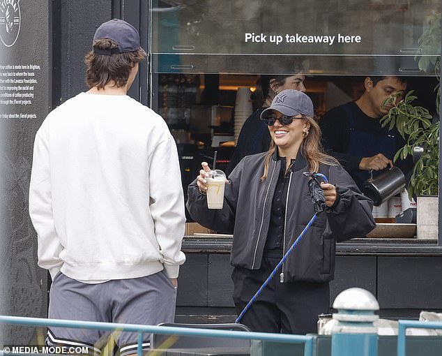 She pushed her hair out of her face with a black New York Yankees baseball cap and wore statement sunglasses as she sipped her coffee.