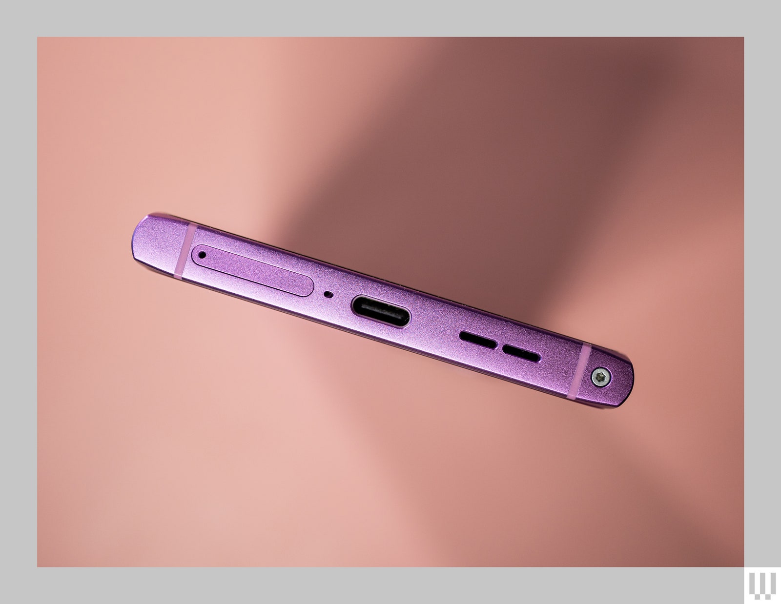 Bottom of a pink mobile phone showing ports and outputs