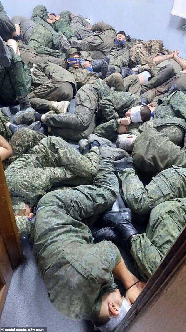 Masked Russian prisoners lay in piles on the ground after their capture in the Kursk region