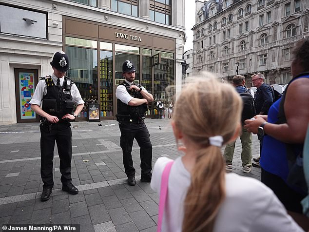 Police have not confirmed a motive for the attack but say it was not terrorism-related (pictured: police officers at the scene in Leicester Square, London)