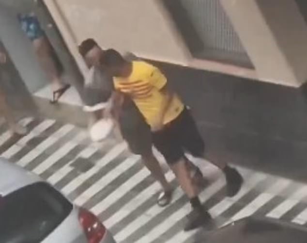 Previous images have also emerged of Nasraoui (in the yellow Barcelona shirt) being led away by a member of the community before police arrived.