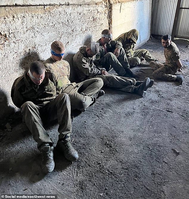 Several soldiers were sitting on the ground blindfolded after surrendering.