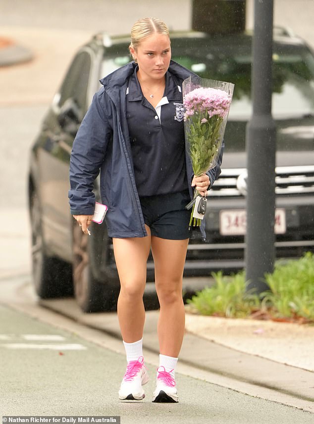 An Emanuel College staff member pays his respects Thursday after the girl was allegedly murdered by her mother.