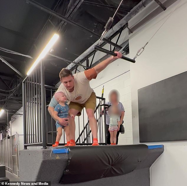 Jarrett Provo is photographed helping his daughter Reighlynn climb the trapeze