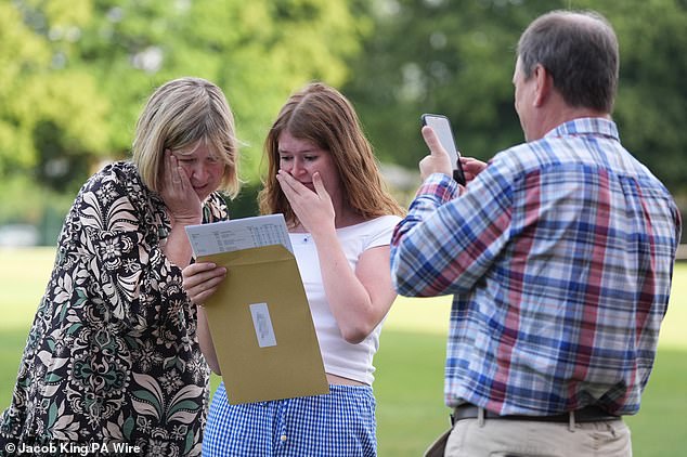 Hannah Greenwood reacts with her parents as she receives her results at Solihull school today