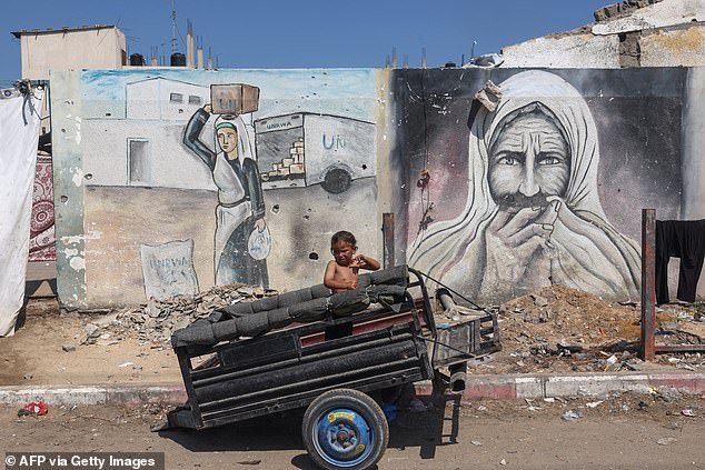 A child sits in a trailer at a makeshift camp for displaced people in Gaza on August 13, 2024.