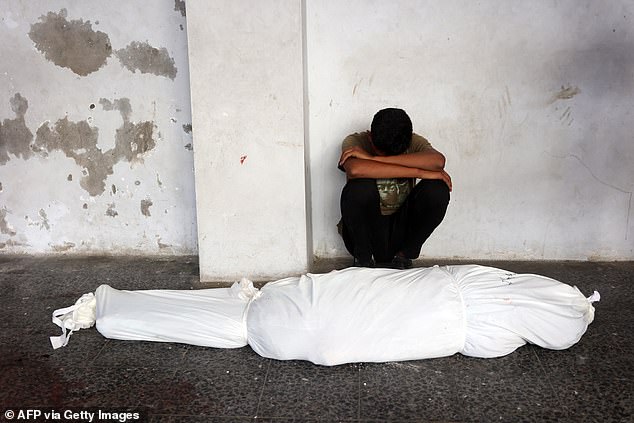 A man mourns the blanket-wrapped body of a relative in Gaza City on August 10.