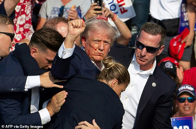 Secret Service agents surround Trump after he was shot on July 13 before escorting him off the stage and to his motorcade.