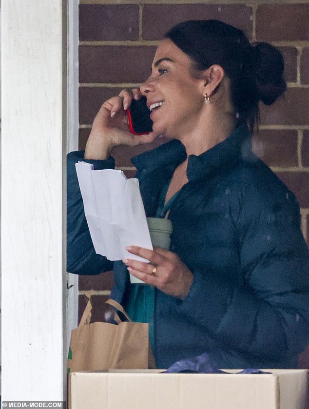 Kate wore a black quilted jacket and sported a chunky gold ring on her left finger as she juggled a cup of coffee and a piece of paper.