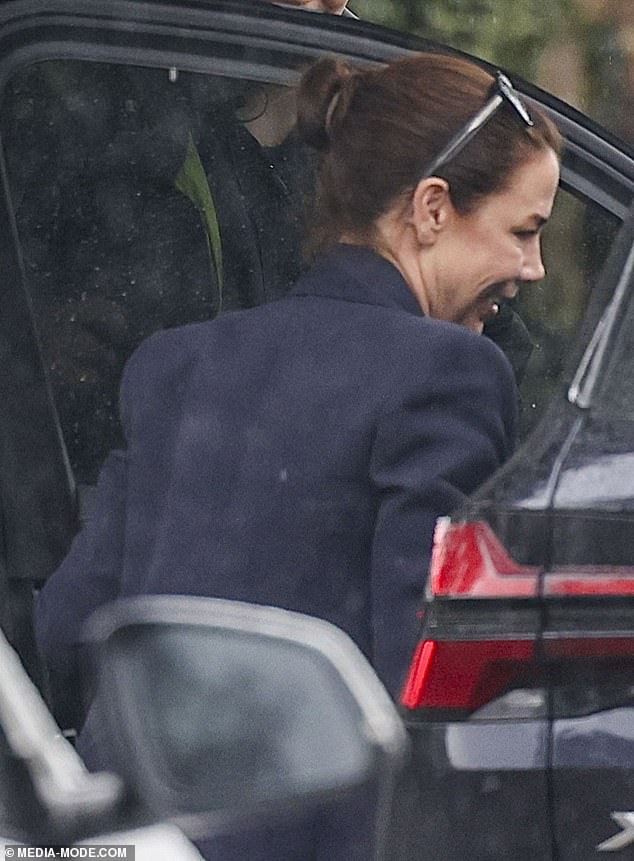 She paired the look with sneakers before braving the wet weather and sneaking into a vehicle parked nearby.