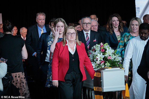 Mrs Carter's coffin is seen with a Hawthorn Hawks AFL team scarf draped over it.