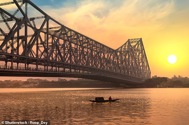 Nicholas begins his slow journey in Kolkata and the boat passes under the city's Howrah Bridge (above)