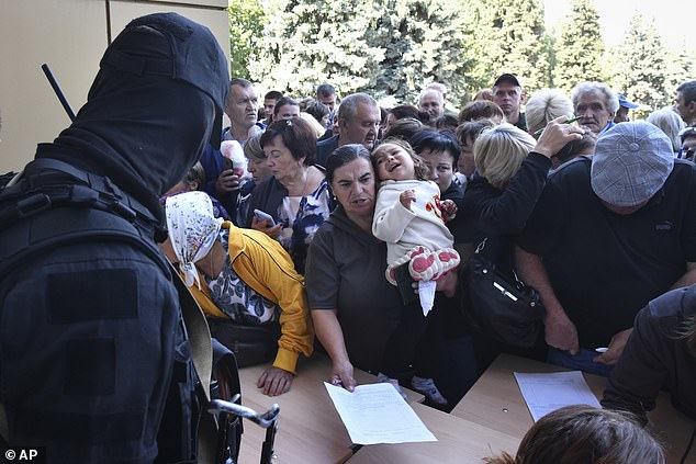 Evacuees in the Kursk region queue to fill out the humanitarian aid form at a humanitarian aid distribution center in Kursk, Russia, Wednesday, Aug. 14, 2024.