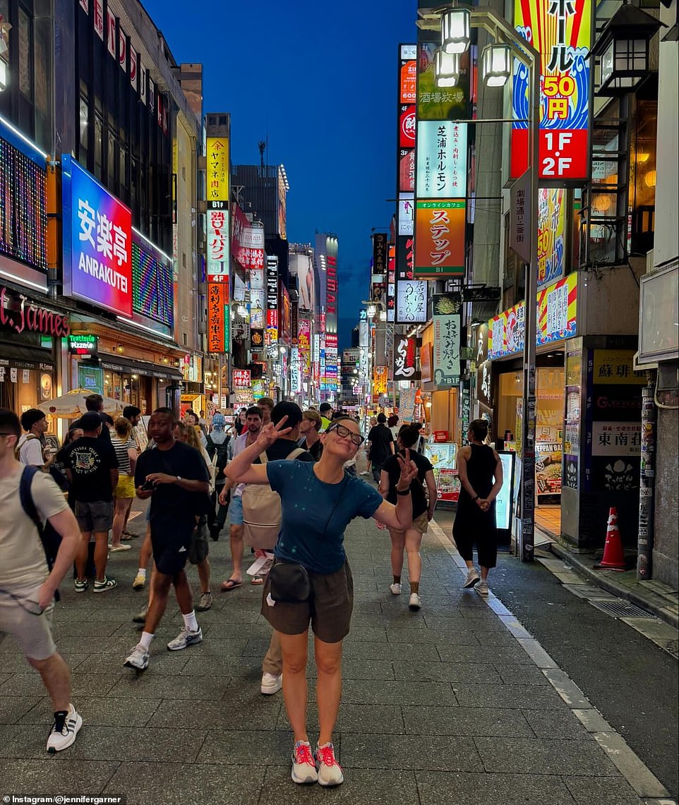 She was seen wearing her glasses as she held up two peace signs on a busy street. 'She pretends to be pro-Tokyo.'