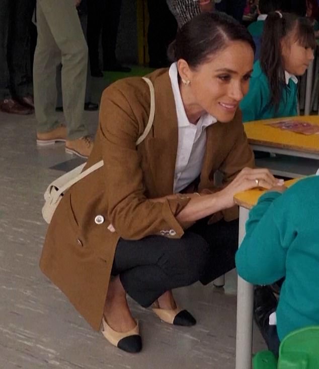 She also carried a small beige bag over her shoulder, with some simple gold jewelry on her wrist.