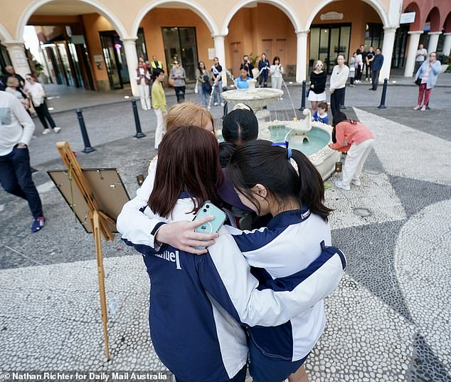 Emerald Lakes residents comfort each other at a vigil for Sophie Wang on Friday