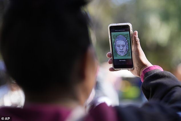 A migrant from Michoacan, Mexico, uses the CBPOne app on Tuesday, Jan. 24, 2023, in Tijuana, Mexico.