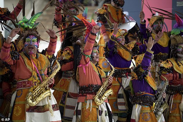 Musicians dressed in traditional carnival costumes perform during a welcome ceremony for Prince Harry and Meghan