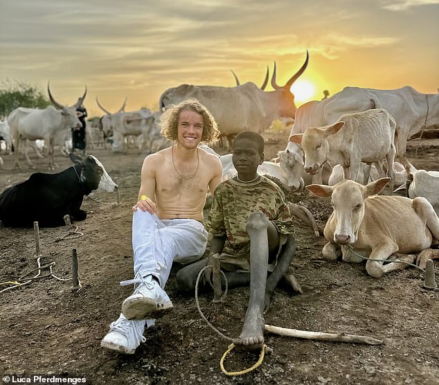 Luca sits with a local in South Sudan, where he says the Mundari tribe 