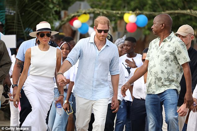 The Duke and Duchess of Sussex walk through the streets on the third day of their visit