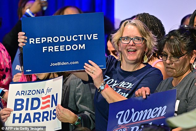 Women hold signs as they wait for U.S. Vice President Kamala Harris to speak about reproductive freedom at the El Rio Neighborhood Center in Tucson on April 12.