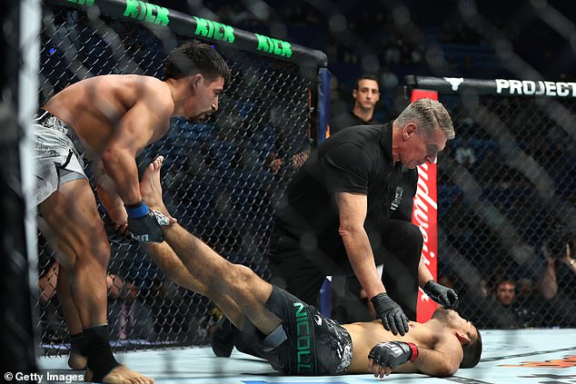 Aguilar (left) showed great sportsmanship by manipulating Nicoll's legs to force blood back to his head in terrifying scenes immediately after his victory.